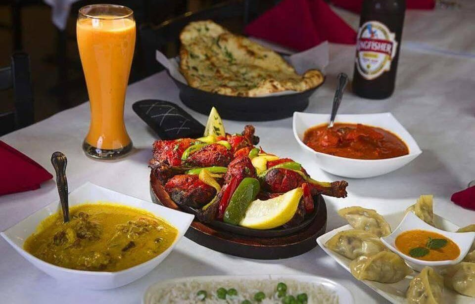 Nepali MoMo and Chowmin House in Las Vegas serving tandoori platter, momos, naan, curry, and mango lassi